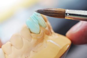 dental technician working on false teeth. table with dental tools.