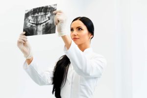 Female Dentist Looking at Dental Xray in Clinic