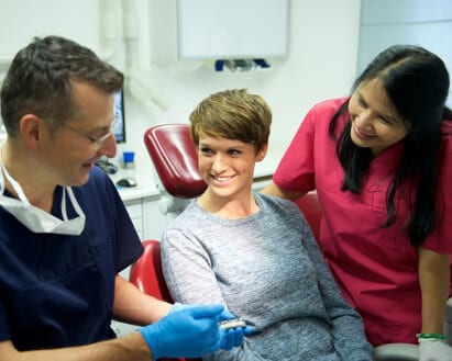 Zahnarzt Dr. Rüdiger Mintert erklärt einer Patientin den Ablauf für Keramik-Veneers