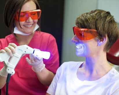 Praxisassistenz härtet Veneers bei einer Patientin mittels UV Licht in der ZPK Herne